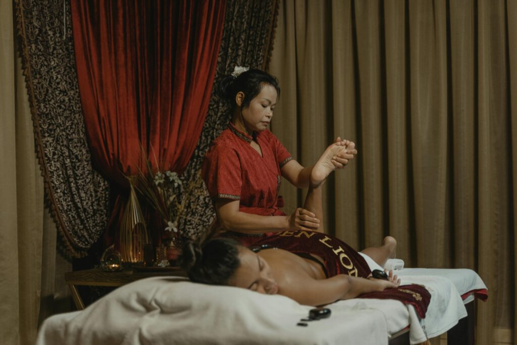 A woman receives a therapeutic massage from a professional masseuse in a calming spa environment.